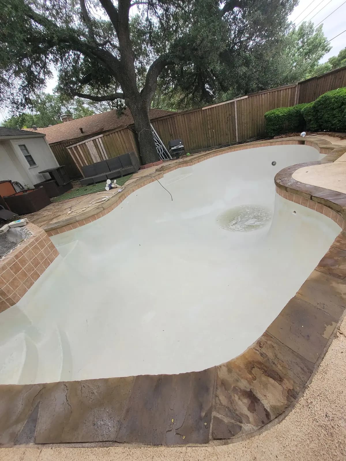 The same pool scrubbed back to clean bare plaster